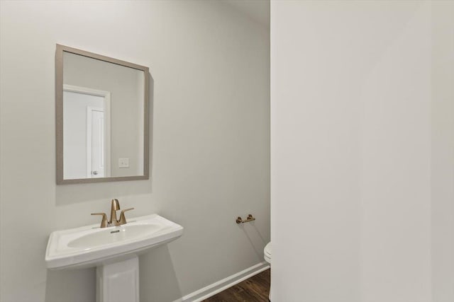 bathroom with hardwood / wood-style flooring, sink, and toilet