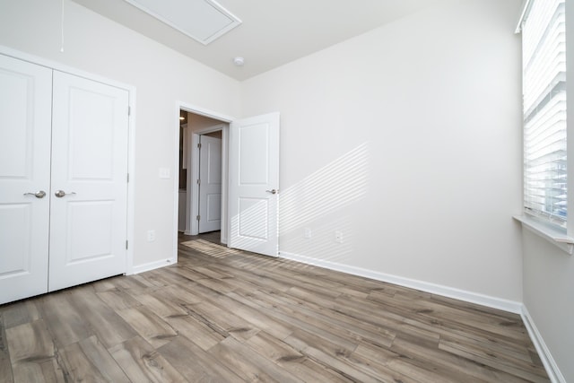 unfurnished bedroom with light hardwood / wood-style flooring and a closet