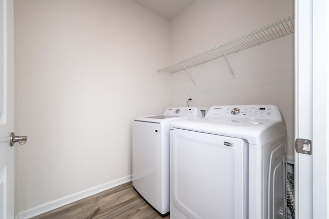 clothes washing area with independent washer and dryer and light hardwood / wood-style floors