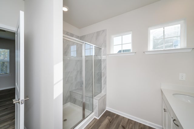 bathroom with wood-type flooring, vanity, and walk in shower