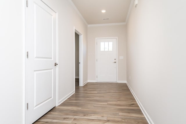 doorway to outside with crown molding and light hardwood / wood-style flooring