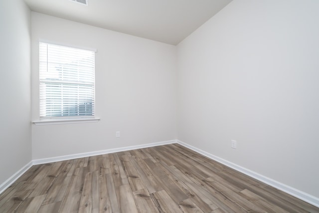 unfurnished room featuring plenty of natural light and hardwood / wood-style floors