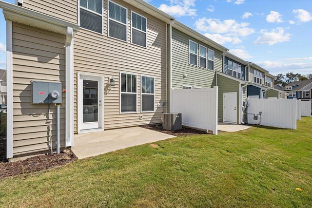 rear view of property featuring a yard, central air condition unit, and a patio area