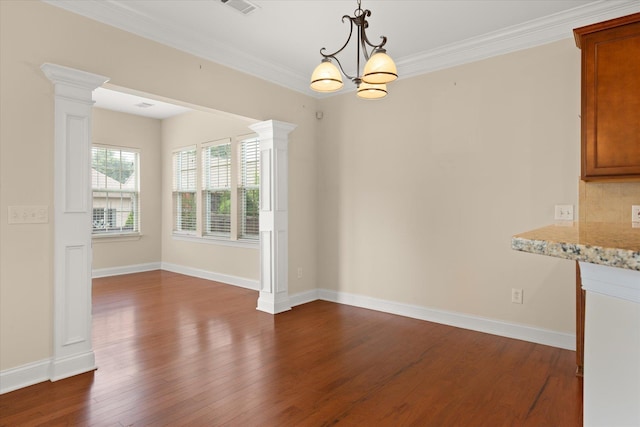 unfurnished dining area with ornate columns, ornamental molding, dark hardwood / wood-style floors, and an inviting chandelier