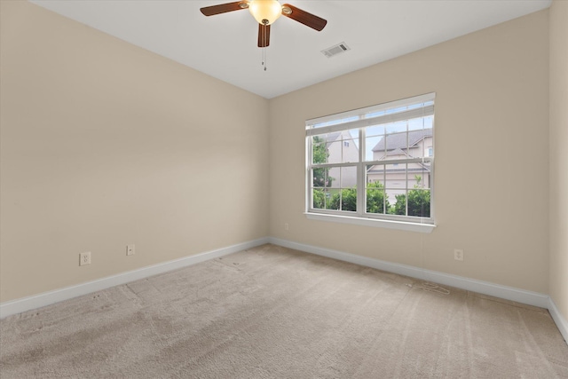 empty room featuring ceiling fan and carpet