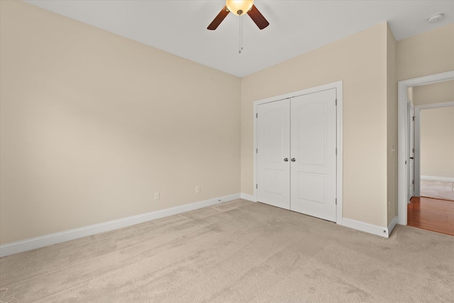 unfurnished bedroom with light colored carpet, ceiling fan, and a closet