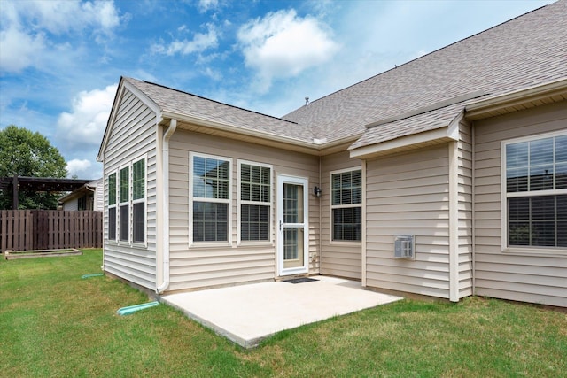 rear view of house with a patio and a yard