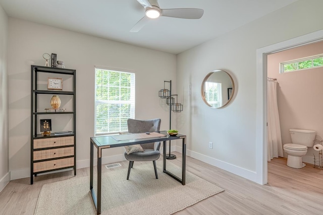 home office with light hardwood / wood-style floors and ceiling fan