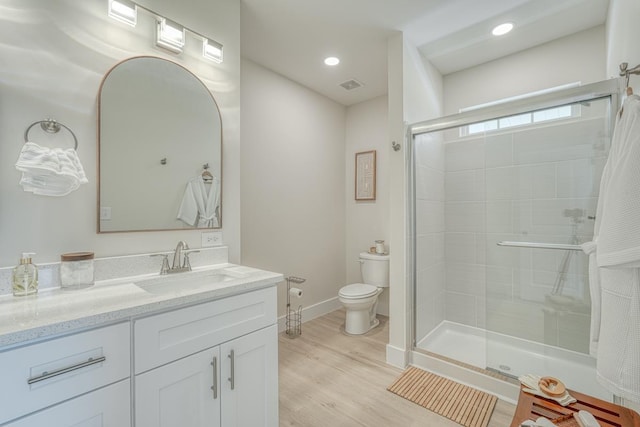 bathroom featuring walk in shower, wood-type flooring, toilet, and vanity