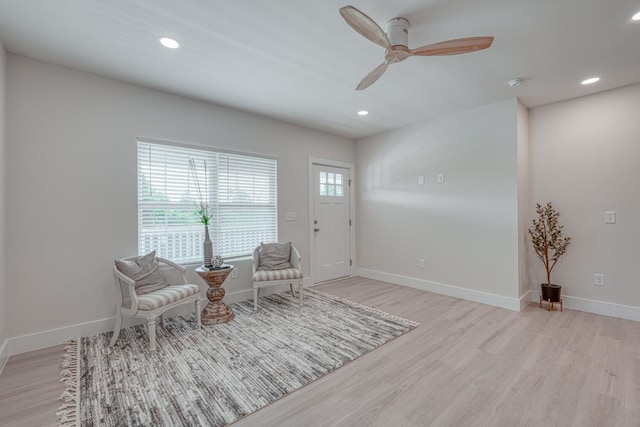 living area featuring ceiling fan and light hardwood / wood-style floors