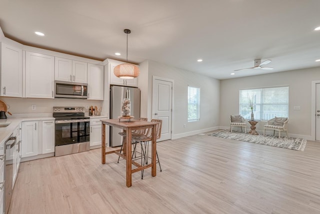 kitchen with white cabinetry, stainless steel appliances, and pendant lighting