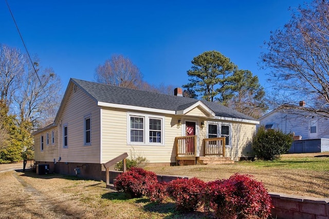 bungalow-style house with central AC and a front yard