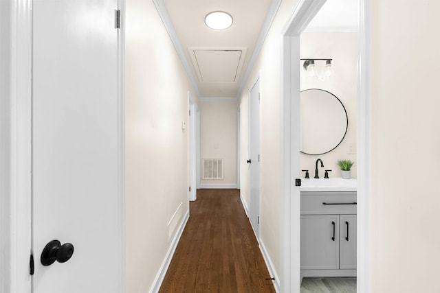 corridor featuring crown molding, dark wood-type flooring, and sink