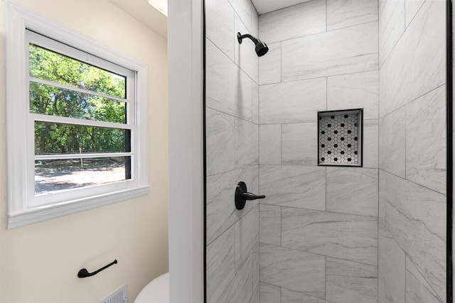 bathroom with toilet and tiled shower