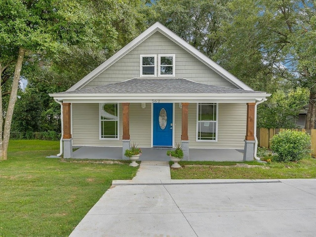 bungalow with a front yard and covered porch