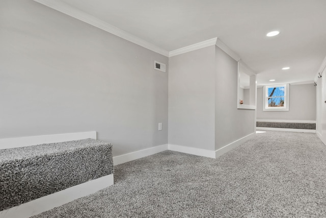 spare room featuring crown molding and carpet