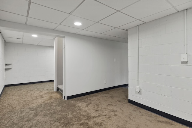 basement with dark carpet and a paneled ceiling