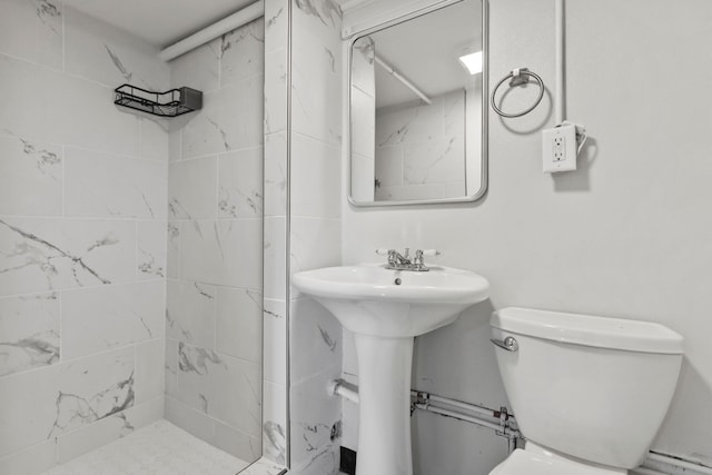 bathroom with tiled shower and toilet