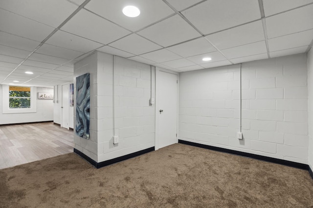 basement featuring carpet floors and a paneled ceiling