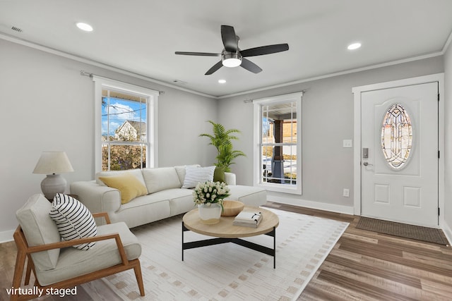 living room with hardwood / wood-style flooring, ornamental molding, and ceiling fan