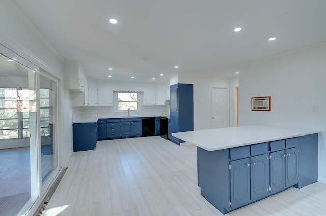 kitchen with dishwasher, white cabinetry, backsplash, blue cabinets, and kitchen peninsula