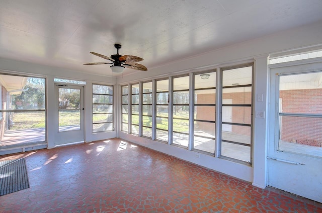 unfurnished sunroom featuring ceiling fan