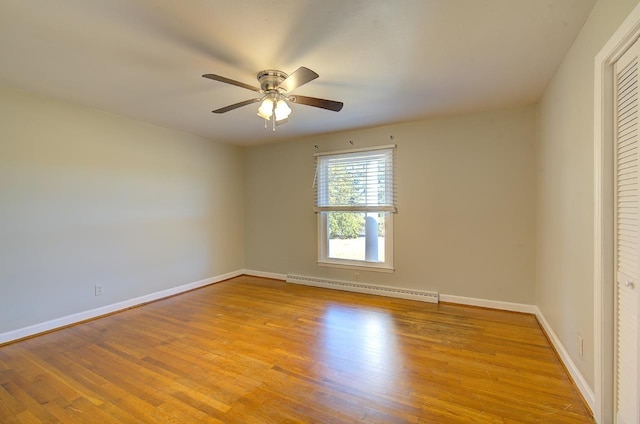 spare room with a baseboard heating unit, ceiling fan, and light hardwood / wood-style flooring