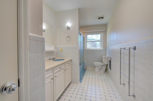 full bathroom with vanity, shower / bath combination with glass door, tile walls, and toilet