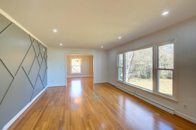 empty room featuring a baseboard radiator, ornamental molding, and light hardwood / wood-style floors