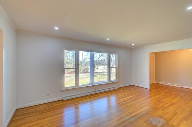 spare room with crown molding, a baseboard radiator, and light hardwood / wood-style floors