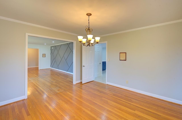 unfurnished room featuring crown molding, light hardwood / wood-style floors, and a notable chandelier