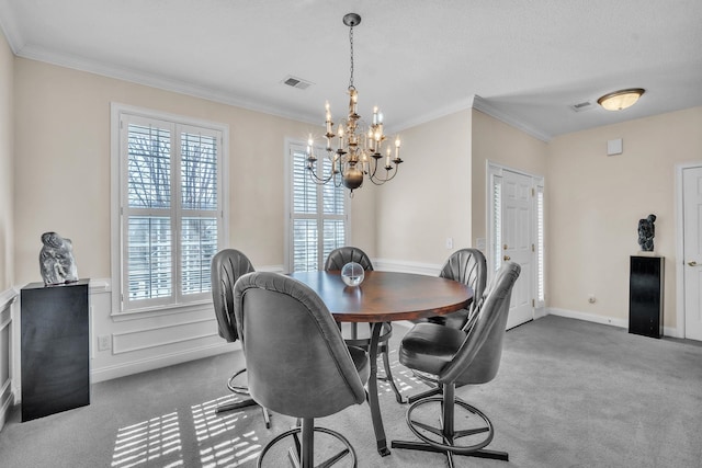 dining room with crown molding, carpet, and a chandelier