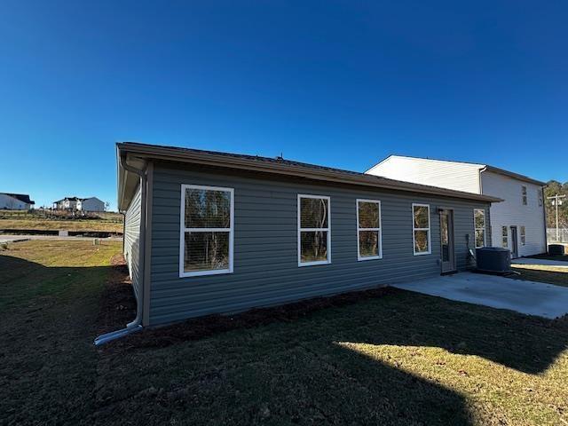 view of side of property featuring a lawn and a patio area