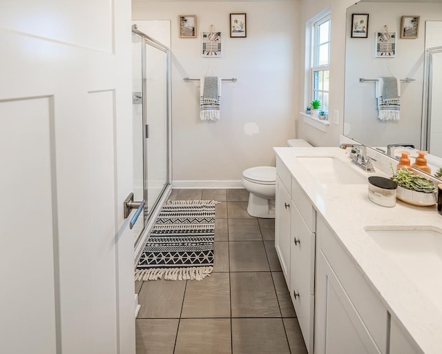 bathroom with vanity, a shower with shower door, tile patterned floors, and toilet