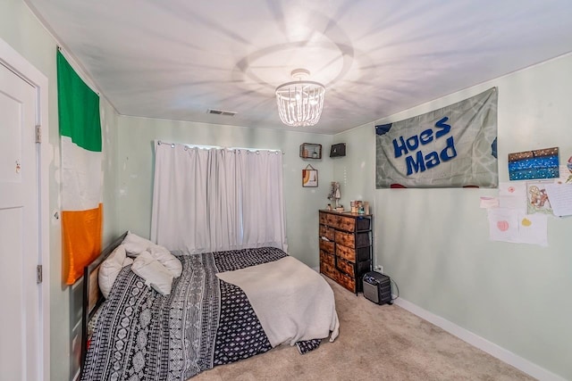 carpeted bedroom featuring an inviting chandelier