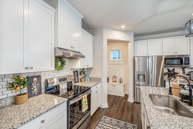 kitchen featuring white cabinetry, appliances with stainless steel finishes, light stone countertops, and sink