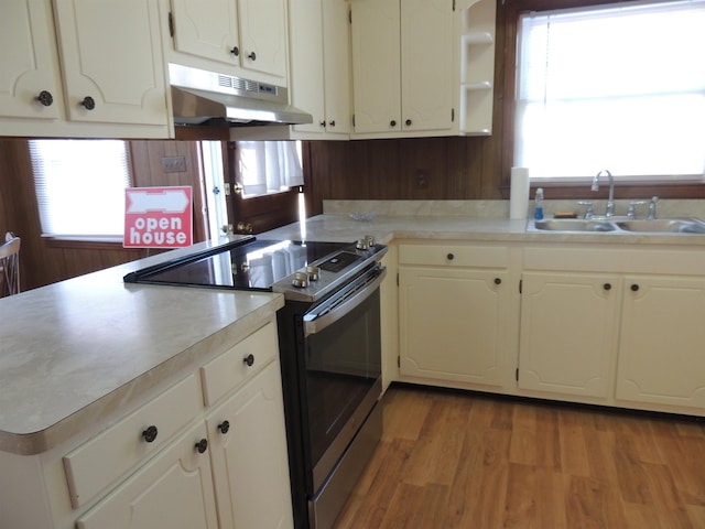 kitchen featuring sink, hardwood / wood-style flooring, white cabinets, and stainless steel electric range oven