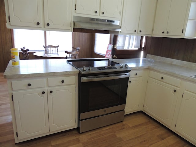 kitchen featuring white cabinets, stainless steel range with electric cooktop, dark hardwood / wood-style flooring, and kitchen peninsula