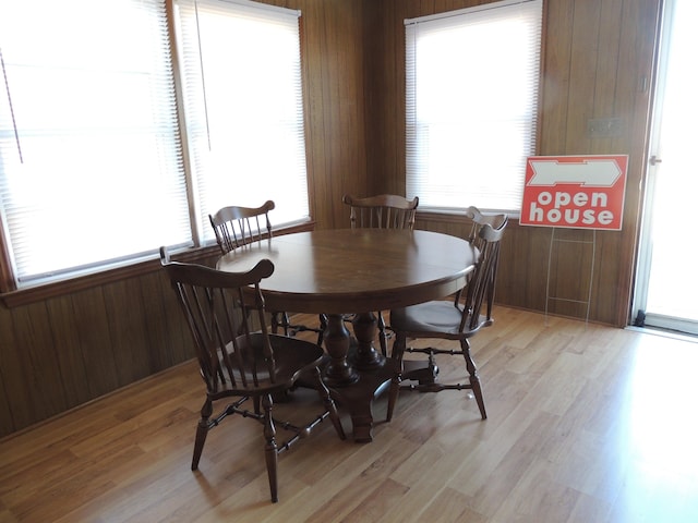 dining room featuring wooden walls and light wood-type flooring