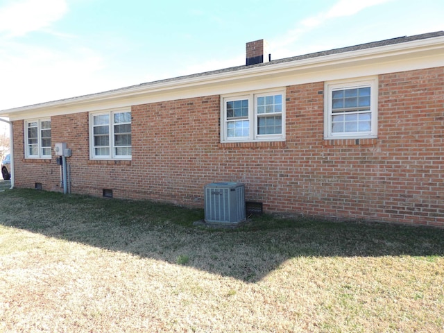 view of property exterior with a yard and central air condition unit