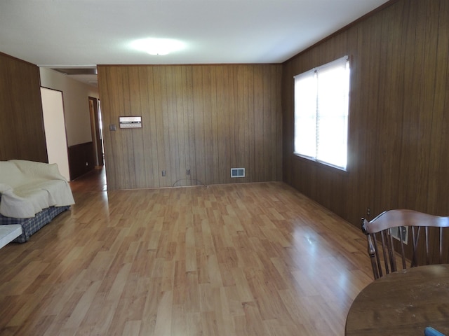 unfurnished room featuring light hardwood / wood-style floors and wood walls