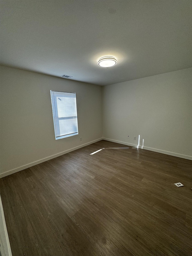 unfurnished room featuring dark wood-type flooring