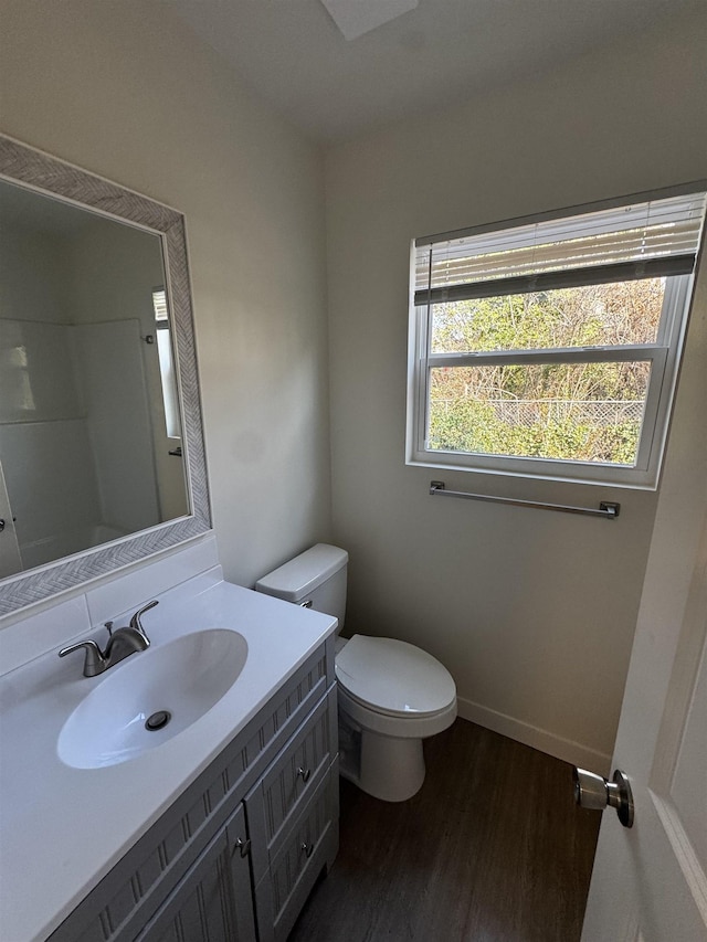 bathroom with hardwood / wood-style flooring, vanity, and toilet