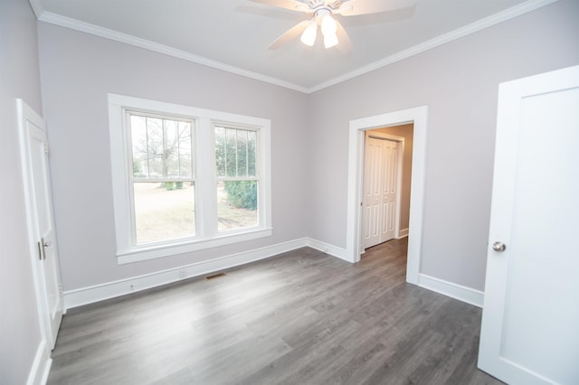 unfurnished room with dark hardwood / wood-style flooring, ornamental molding, and ceiling fan