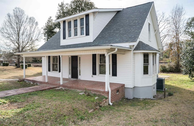 view of front of home featuring a porch, a front lawn, and central air condition unit