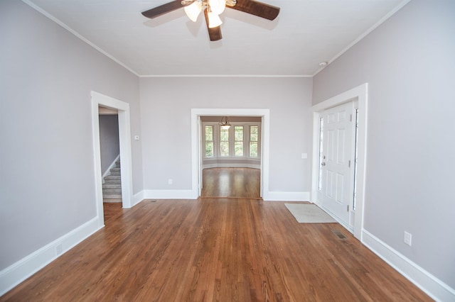 empty room with crown molding, ceiling fan, and dark hardwood / wood-style flooring