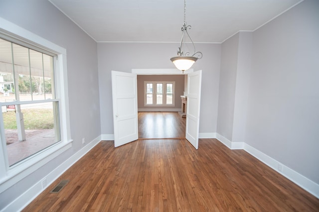 unfurnished dining area with dark wood-type flooring