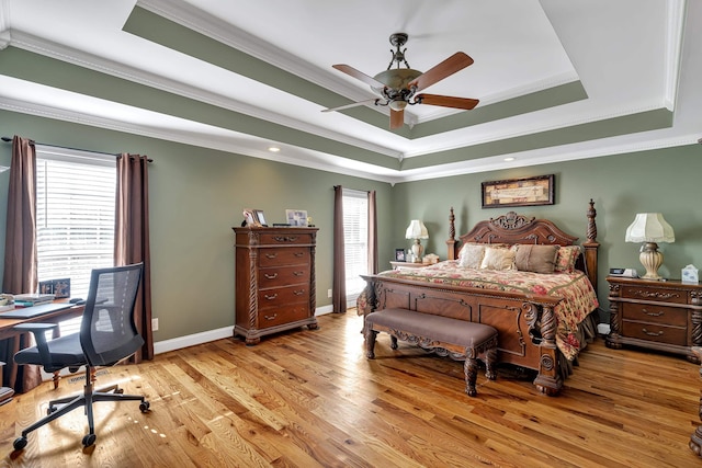 bedroom featuring ornamental molding, a raised ceiling, ceiling fan, and light wood-type flooring