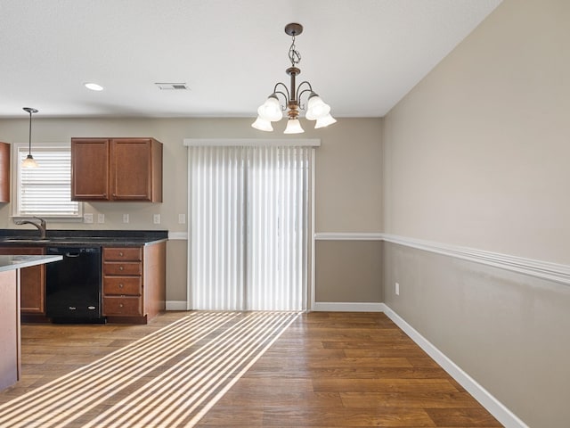 kitchen with dishwasher, dark wood-type flooring, pendant lighting, and a notable chandelier