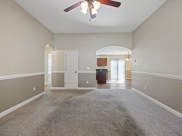 spare room with light carpet and ceiling fan with notable chandelier